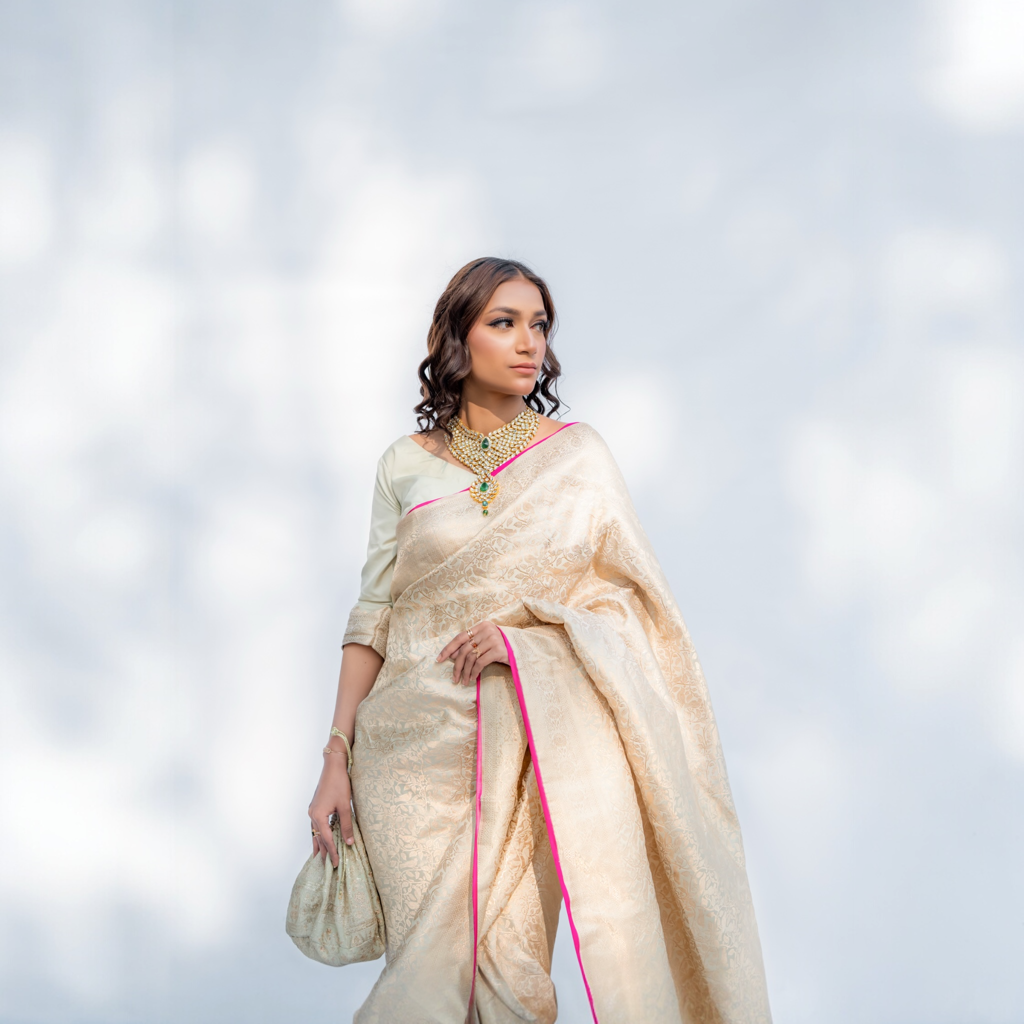 Woman wearing a Pistachio green Katan silk Banarasi saree with Shikargah motif from Ivory Whisper collection with a blurred background