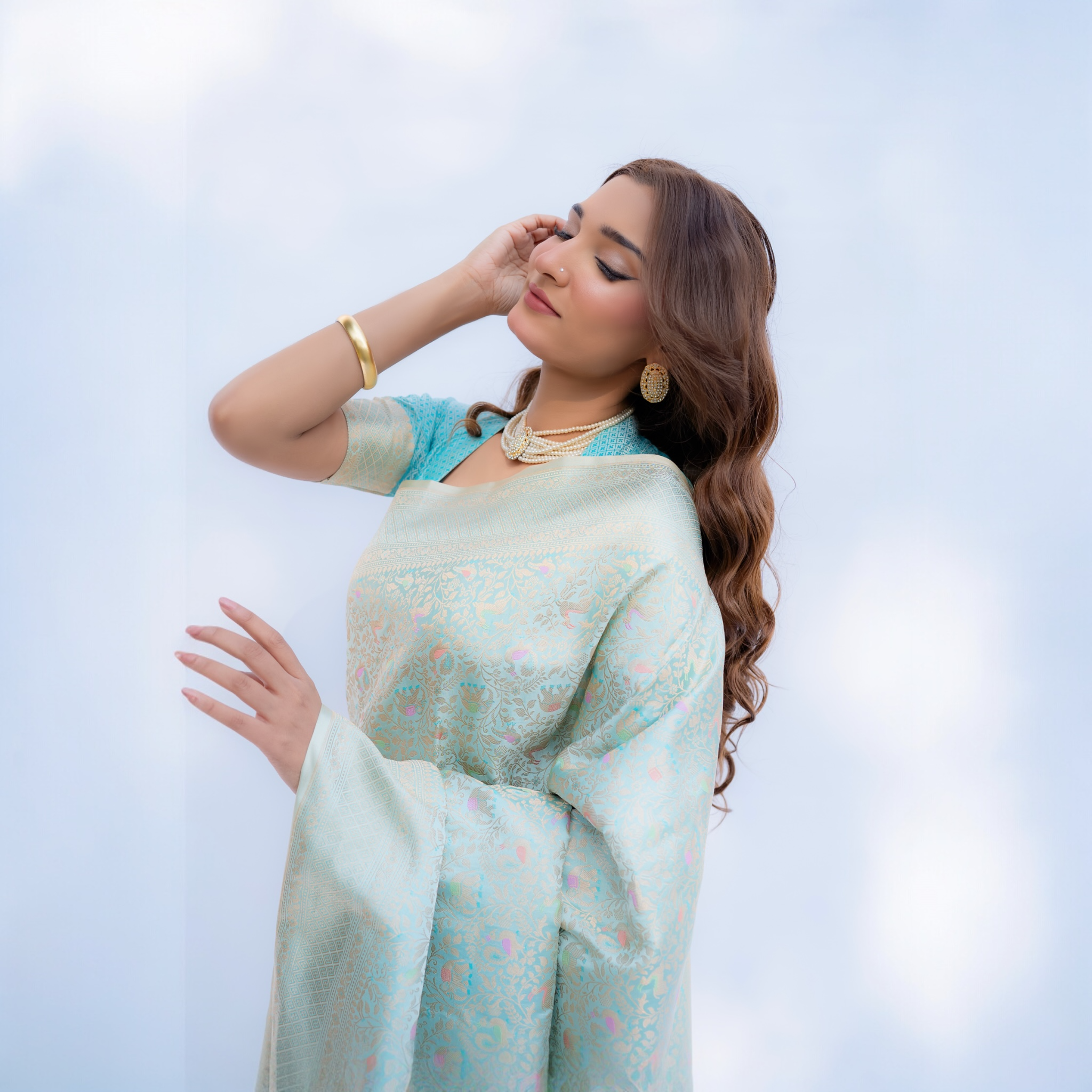 Woman wearing a Aqua blue Katan silk Banarasi saree with Shikargah motif from Shades of Ivory Whisper collection